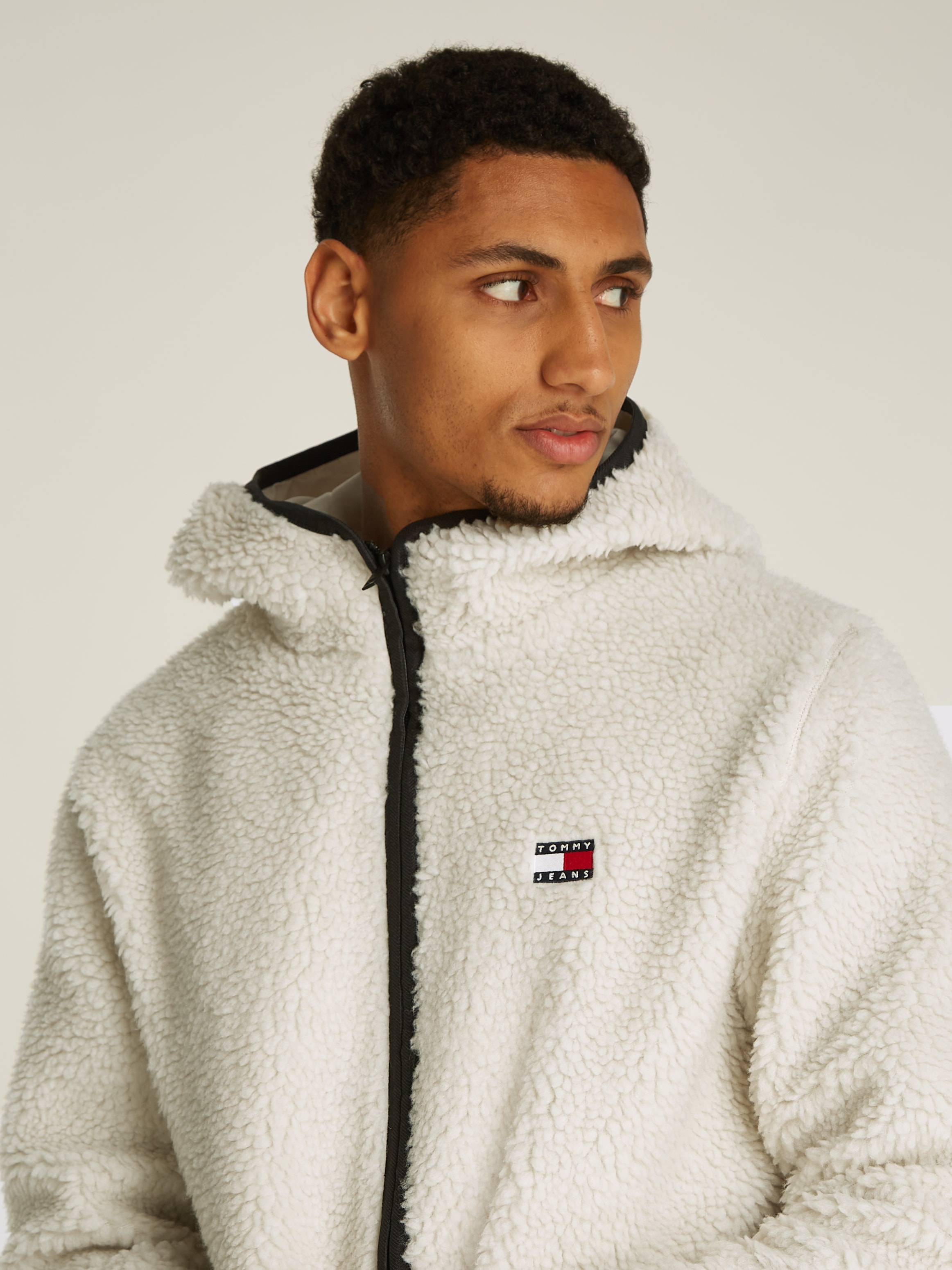 Tommy Jeans Plüschjacke »TJM REG BADGE TEDDY ZIP TRU EXT«, mit Kapuze, mit Logopatch, leicht überschnittene Schultern