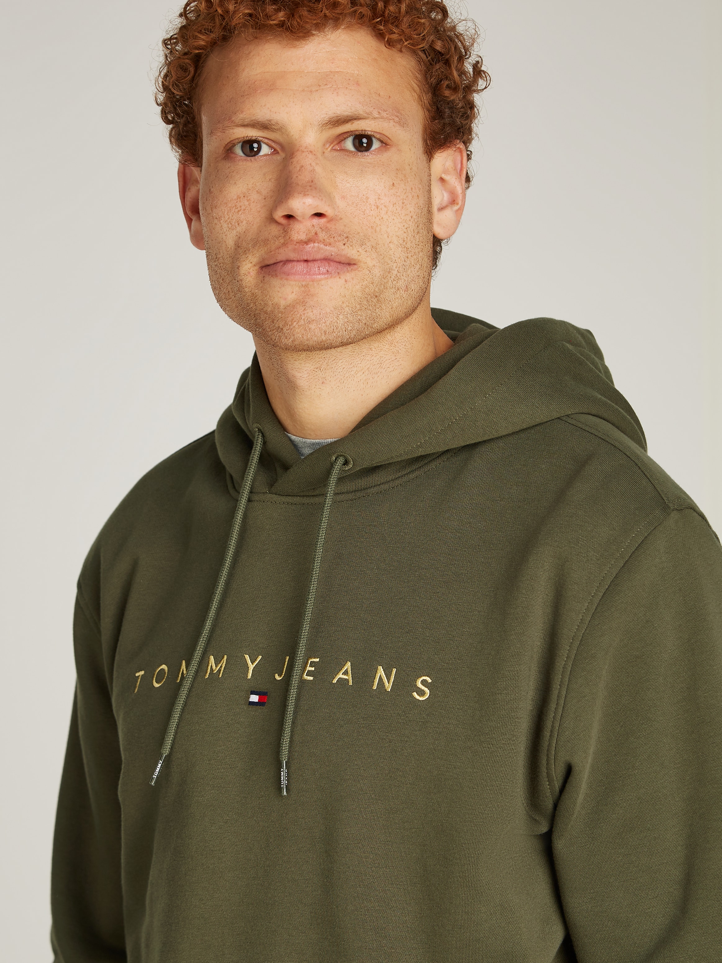 Tommy Jeans Sweatshirt »TJM REG LINEAR GOLD HOOD EXT«, besticktes Markenlogo auf Brusthöhe