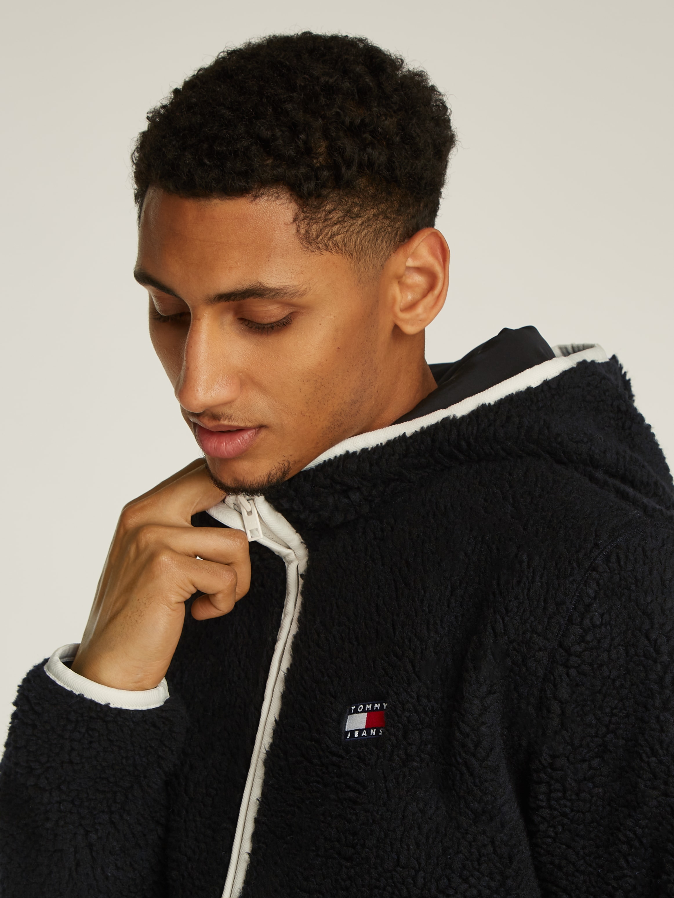 Tommy Jeans Plüschjacke »TJM REG BADGE TEDDY ZIP TRU EXT«, mit Kapuze, mit Logopatch, leicht überschnittene Schultern